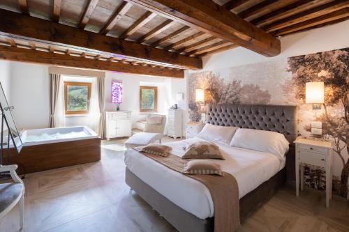 a bedroom with a large bed and a bath tub at Il Castelluccio Country Resort Restaurant & SPA in Barberino di Mugello