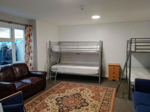 a living room with two bunk beds and a couch at Dolphins Backpackers in Tintagel