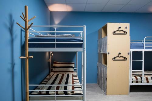 a room with bunk beds and a blue wall at 日月彩舟 日月潭背包客旅店 Sun Moon Lake Rainbow SUP Hostel in Yuchi