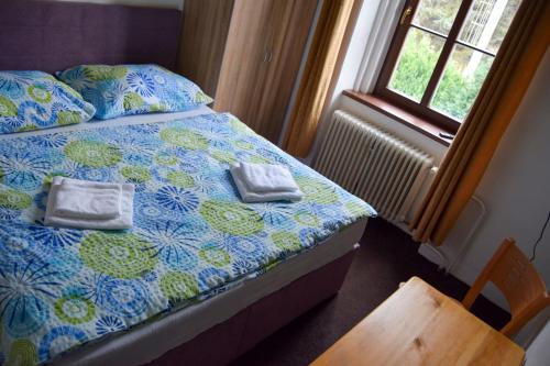 a bedroom with a bed with two towels on it at Penzion Betty in Okounov