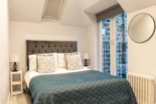 a bedroom with a bed and a large window at The Old Coach House- luxury Harrogate Home Detached Quite Stylish whole house short walk from the Conference- town centre in Harrogate