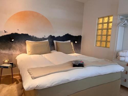 Ankogel Lofts Mallnitz في مالنيتز: غرفة نوم بسرير مع لوحة على الحائط