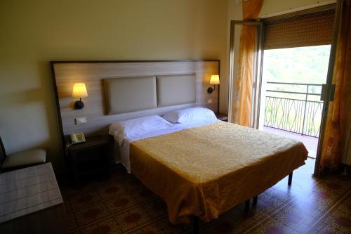 a bedroom with a bed and a large window at Amelia Dream View Hotel in Momigno