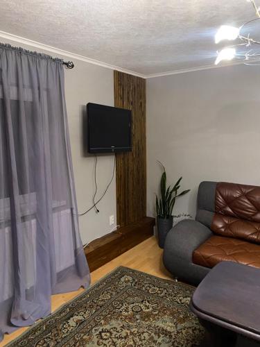 a living room with a couch and a flat screen tv at Zator apartaments in Vyshkiv