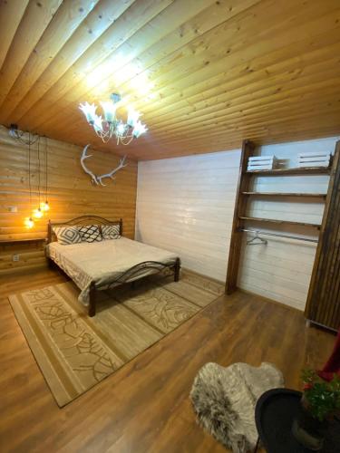 a bedroom with a bed in a wooden room at Zator apartaments in Vyshkiv