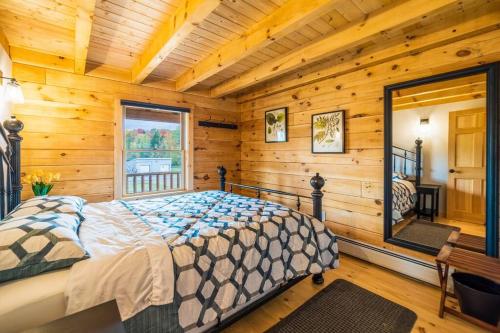a bedroom with a bed in a room with wooden walls at Florida Mountain Log Cabin in Florida