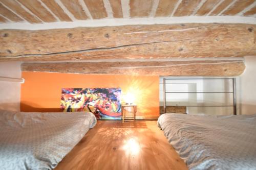 a bedroom with two beds and a painting on the wall at Les Mats Du Port in Marseille