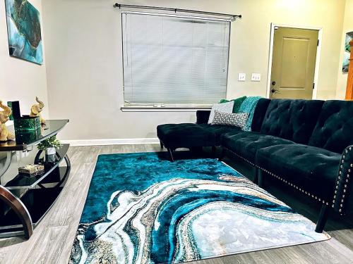 een woonkamer met een groene bank en een blauw tapijt bij Atlanta Beltline Retreat in Atlanta