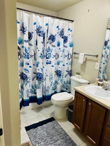 een badkamer met een toilet en een blauw-wit douchegordijn bij Atlanta Beltline Retreat in Atlanta