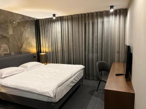 - une chambre avec un lit, un bureau et une télévision dans l'établissement Chalet Deux A, à Bad Kleinkirchheim