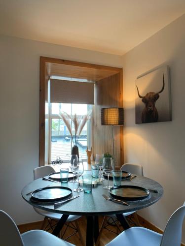 a dining room table with glasses and a bull head on the wall at Orkney Staycations - Orcadale in Orkney