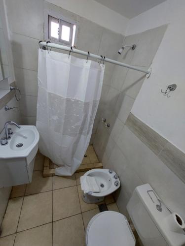 a white bathroom with a toilet and a sink at Las3B 6 in General Roca