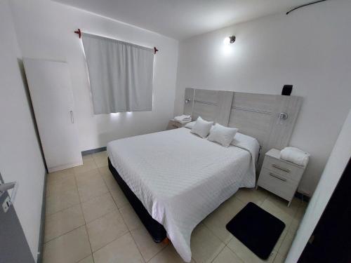 Un dormitorio blanco con una cama blanca y una ventana en Las3B 6 en General Roca