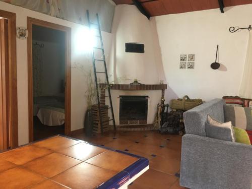 sala de estar con sofá y chimenea en Cortijo andaluz en Sierra Morena - Naturaleza, en Villaviciosa de Córdoba