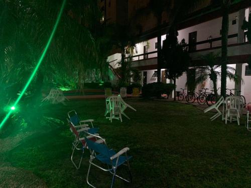 a group of chairs in the yard of a building at night at Hotel Praia Bonita in Capão da Canoa