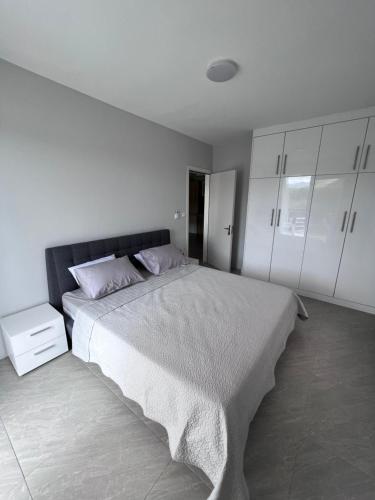 a bedroom with a large bed and white cabinets at Top-Floor Modern 3BD Penthouse with Beautiful Mountain View Terrace - 5 min Walk to Beach in Flic-en-Flac