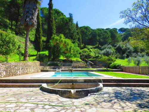 einen Pool im Garten mit Palmen in der Unterkunft One bedroom house with lake view shared pool and furnished garden at Porto de Mos in Porto de Mós