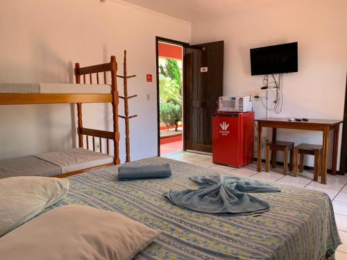 a bedroom with a bed and a desk and a television at Hotel Praia Bonita in Capão da Canoa