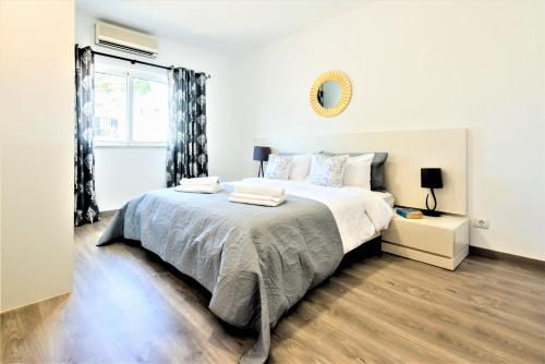 ヴァーレ・ド・ローボにあるVale do Lobo Apartment Bの白いベッドルーム(大型ベッド1台、窓付)