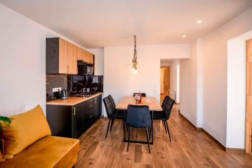 a kitchen and dining room with a table and chairs at Apartamenty u Burego in Biały Dunajec