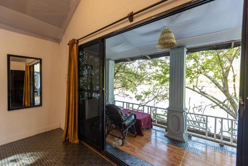 a room with a balcony with a chair and a window at Dreamcatcher By Brifton Hotel And Resorts in Palolem