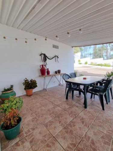 eine Terrasse mit einem Tisch, Stühlen und Pflanzen in der Unterkunft Casa da Mae in Salir