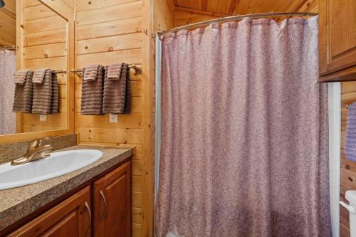 a bathroom with a shower curtain and a sink at Quiet little pet friendly cabin in Kernville