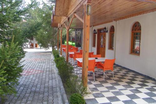 a restaurant with orange tables and chairs on a checkered floor at Hotel Aşıkoğlu in Bogazkale
