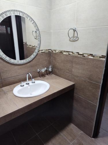 un baño con lavabo y espejo en Los departamentos de Eva, en San Antonio Oeste