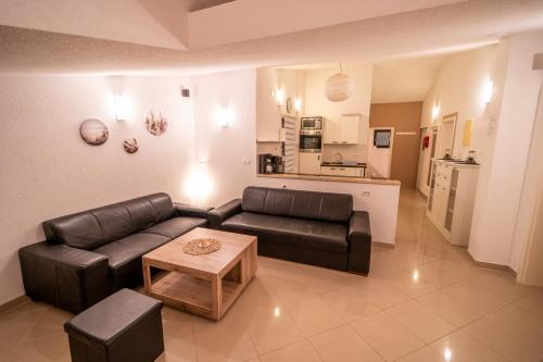 un soggiorno con un divano in pelle e un tavolo di Villa Twins Markovic a Pola (Pula)
