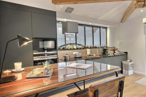 a kitchen with a glass counter top and a table at On dirait LE SUD in Andrézieux-Bouthéon