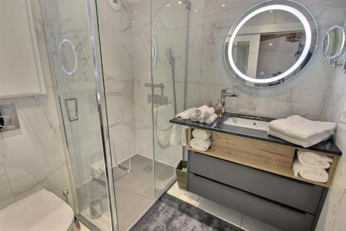 La salle de bains est pourvue d'une douche, d'un lavabo et d'un miroir. dans l'établissement On dirait LE SUD, à Andrézieux-Bouthéon