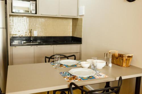 una cocina con una mesa con platos. en Estudio pratico no Centro de Floripa, 900 metros do CentroSul P1617, en Florianópolis
