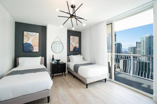two beds in a bedroom with a large window at City views at brickell miami in Miami