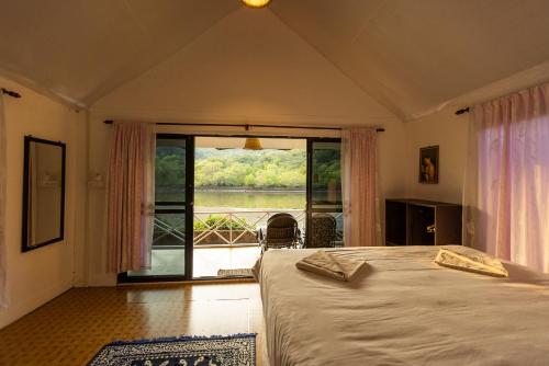 1 dormitorio con 1 cama y vistas a un balcón en DreamCatcher Unique Retreat Yoga & Spa, en Palolem