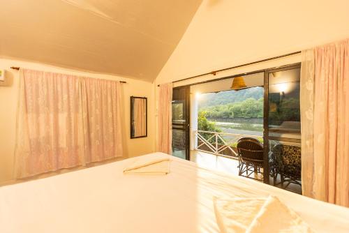 a bedroom with a bed and a view of a balcony at Dreamcatcher By Brifton Hotel And Resorts in Palolem