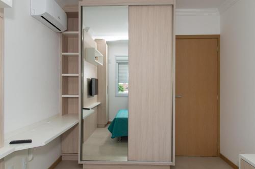 een glazen deur leidt naar een kamer met een slaapkamer bij 2 quadras da Praia em Canasvieiras, Piscina e Churrasqueira P1595 in Florianópolis