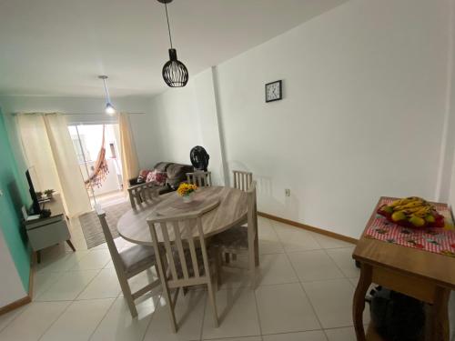 cocina y comedor con mesa y sillas en Apartamento Aconchegante, en Bombinhas