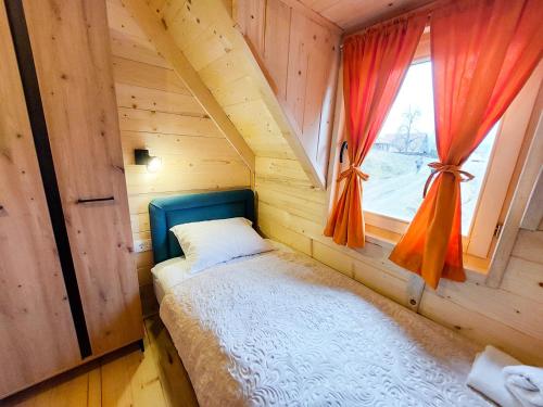 a bedroom with a bed in a wooden room with a window at Dušan_guest_house in Kolašin