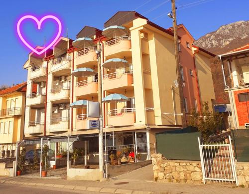 a building with a heart sign in front of it at Apartmani BAKULE in Peštani