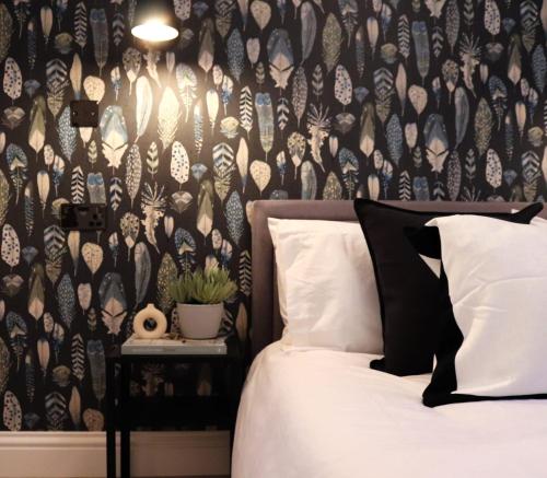 a bedroom with a bed with a black and white wallpaper at Cozy 1BR in Headington Oxford w off-road Parking in Oxford