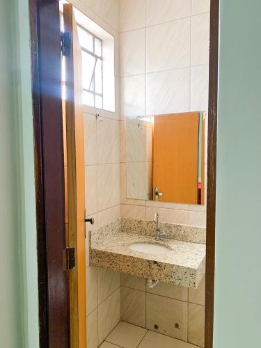 a bathroom with a sink and a mirror at Hotel Central de Anápolis in Anápolis