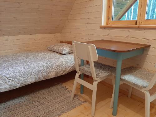 a room with a desk and a bed and a table at Suurepera puhkekeskuse saunamaja 