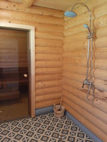 a bathroom with a shower in a wooden wall at Suurepera puhkekeskuse saunamaja 