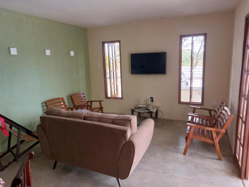 a living room with a couch and a flat screen tv at Recanto ViVa - Catuama in Goiana