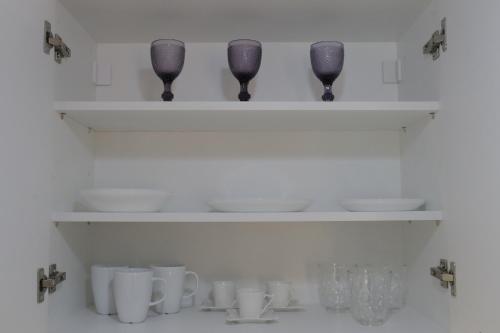 a shelf with wine glasses and vases on it at Helen's Little Castle free private parking in Thessaloniki