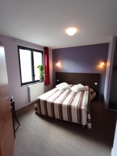 1 dormitorio con cama y ventana en Hôtel du Commerce en Pléaux