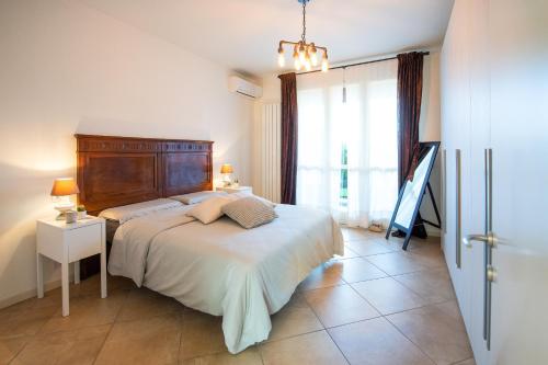 um quarto com uma cama e uma grande janela em Lago di Garda a 300m House in Manerba em Manerba del Garda