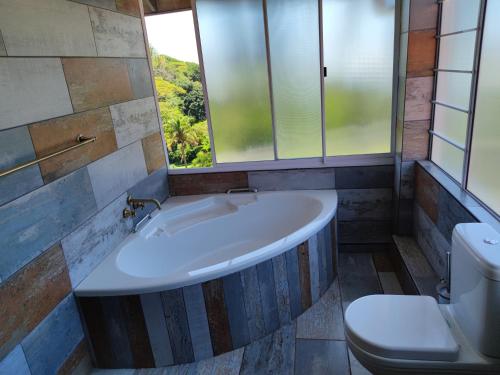 a bathroom with a tub and a toilet and a window at Peace of Mind Holiday Home in Amanzimtoti