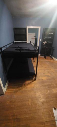 ein schwarzes Bett in einem Zimmer mit Holzboden in der Unterkunft Zen Hostel in Toronto